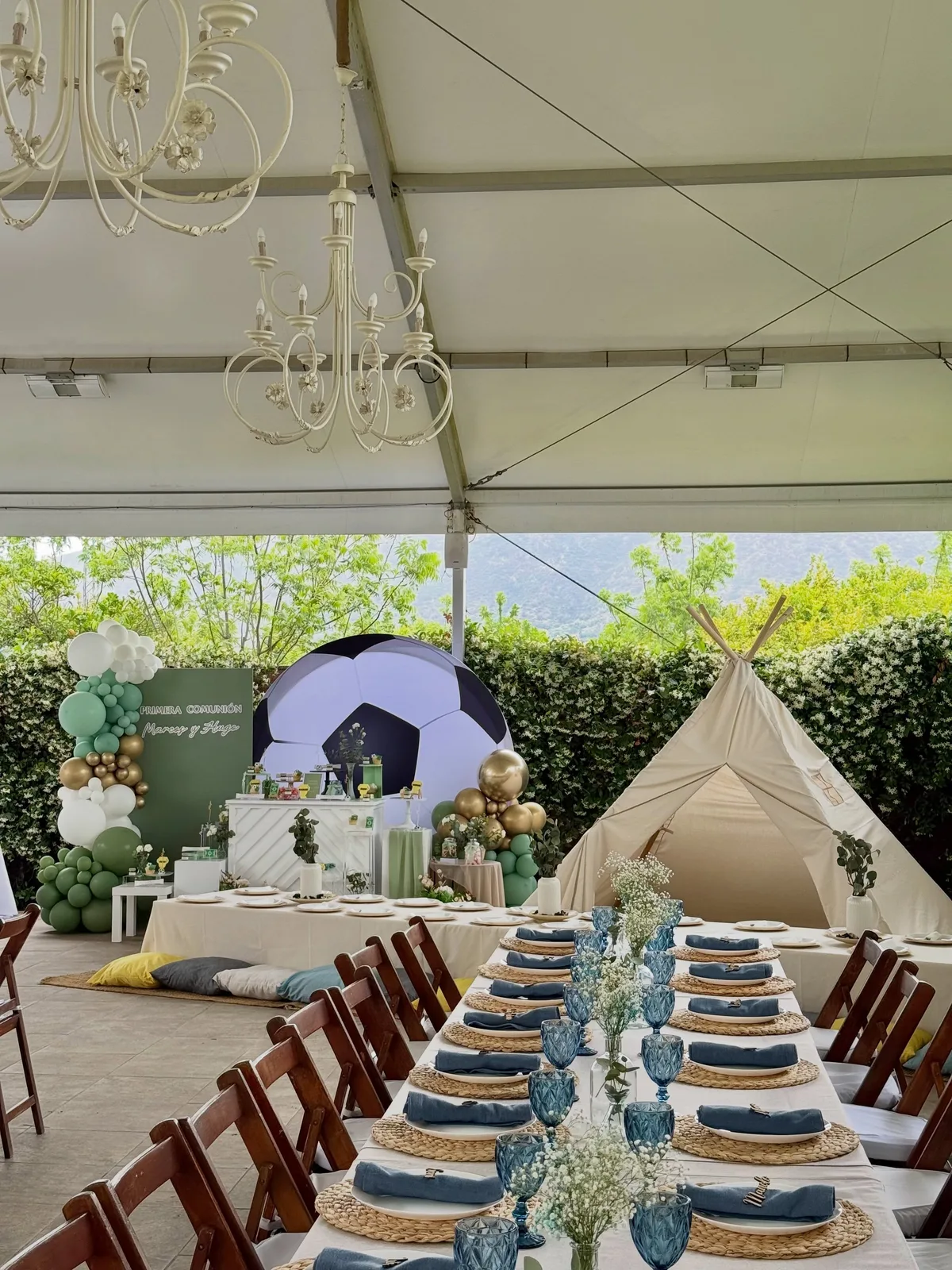 Mesa de comunión al aire libre con decoración azul y carpa infantil en Málaga