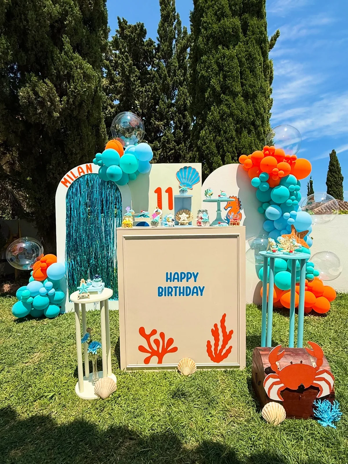 Decoración de cumpleaños con temática marina y globos en un jardín de Málaga