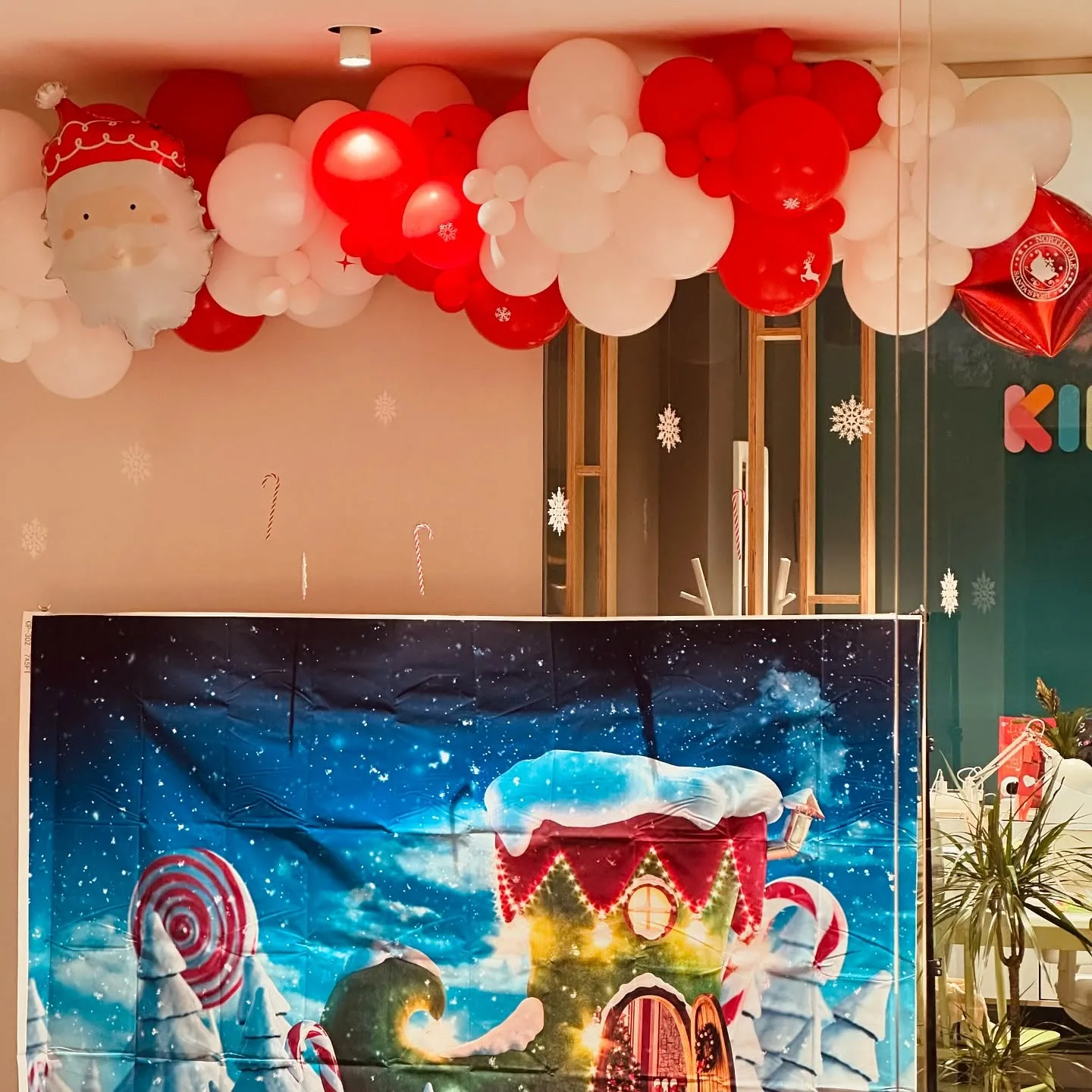 Decoración navideña corporativa con arco de globos rojos y blancos en Málaga