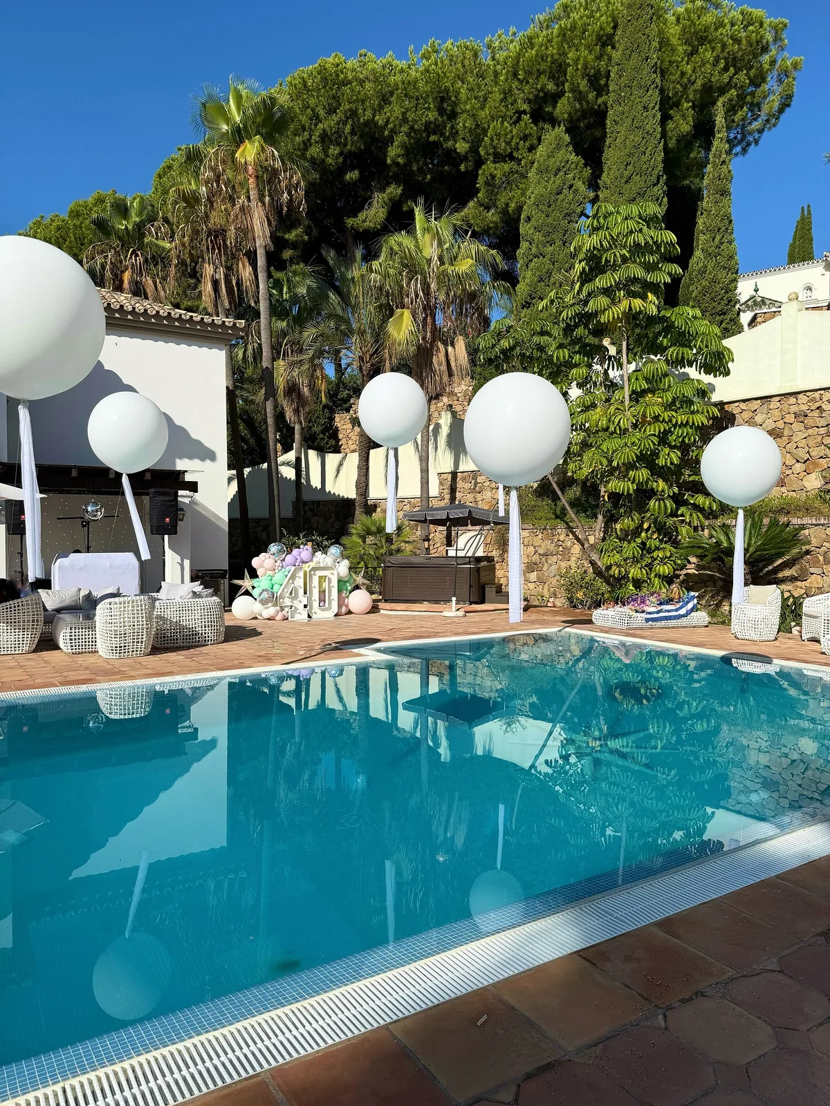 Decoración de baby shower alrededor de una piscina con globos blancos en Málaga