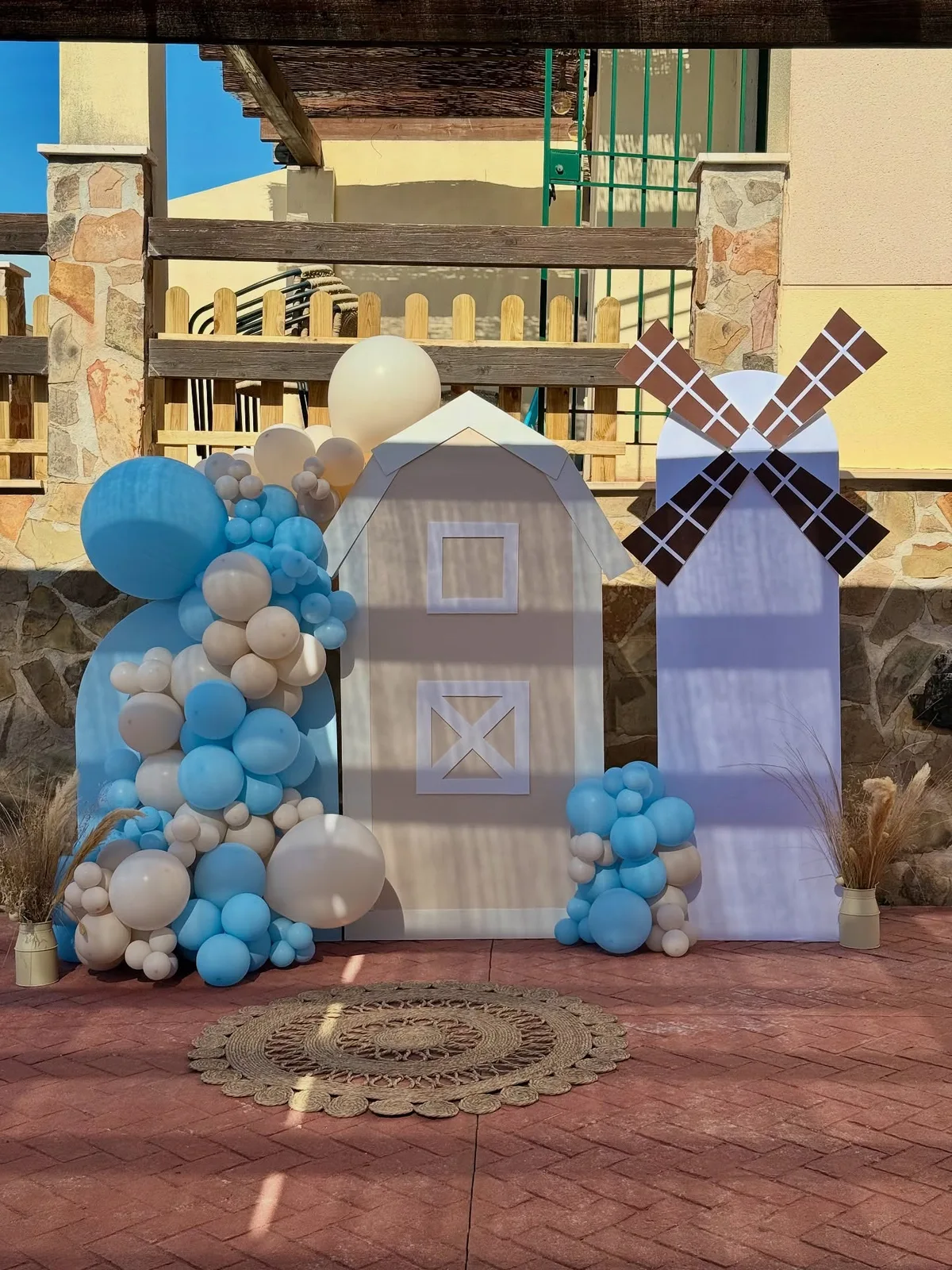 Photocall de cumpleaños con molinos, globos azules y nubes en Málaga