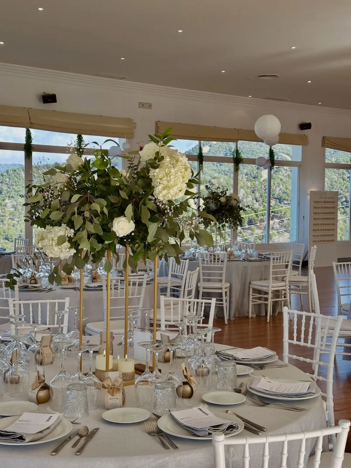 Mesa de boda con centros altos de flores blancas en Málaga
