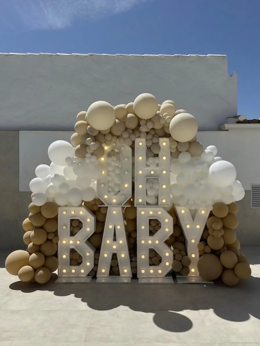 Photocall Oh Baby en tonos beige y blanco bajo la luz del sol en Málaga